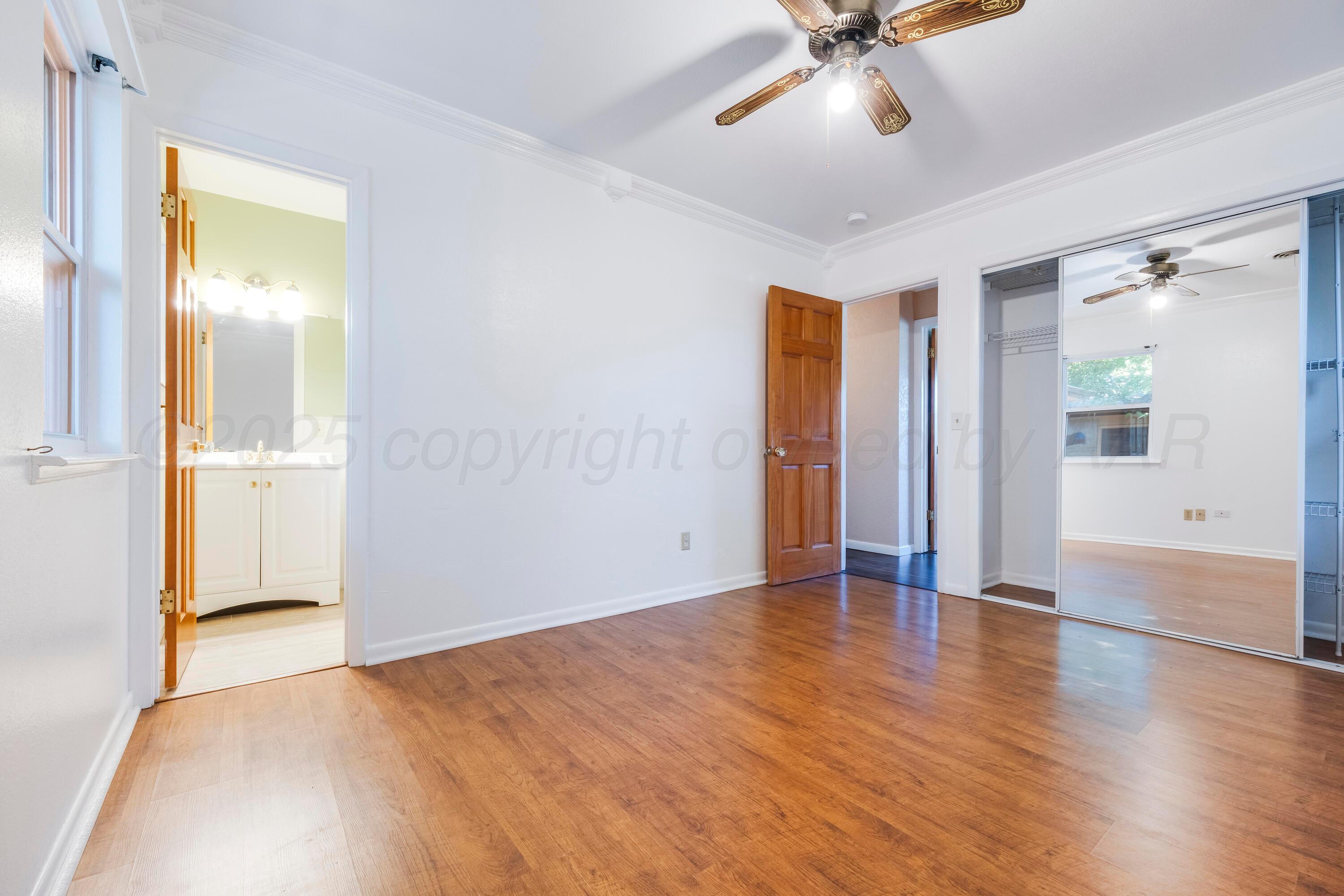 2401 Darrell Avenue Amarillo, TX 79110 - Photo 22 of 35 an empty room with wooden floor and a ceiling fan