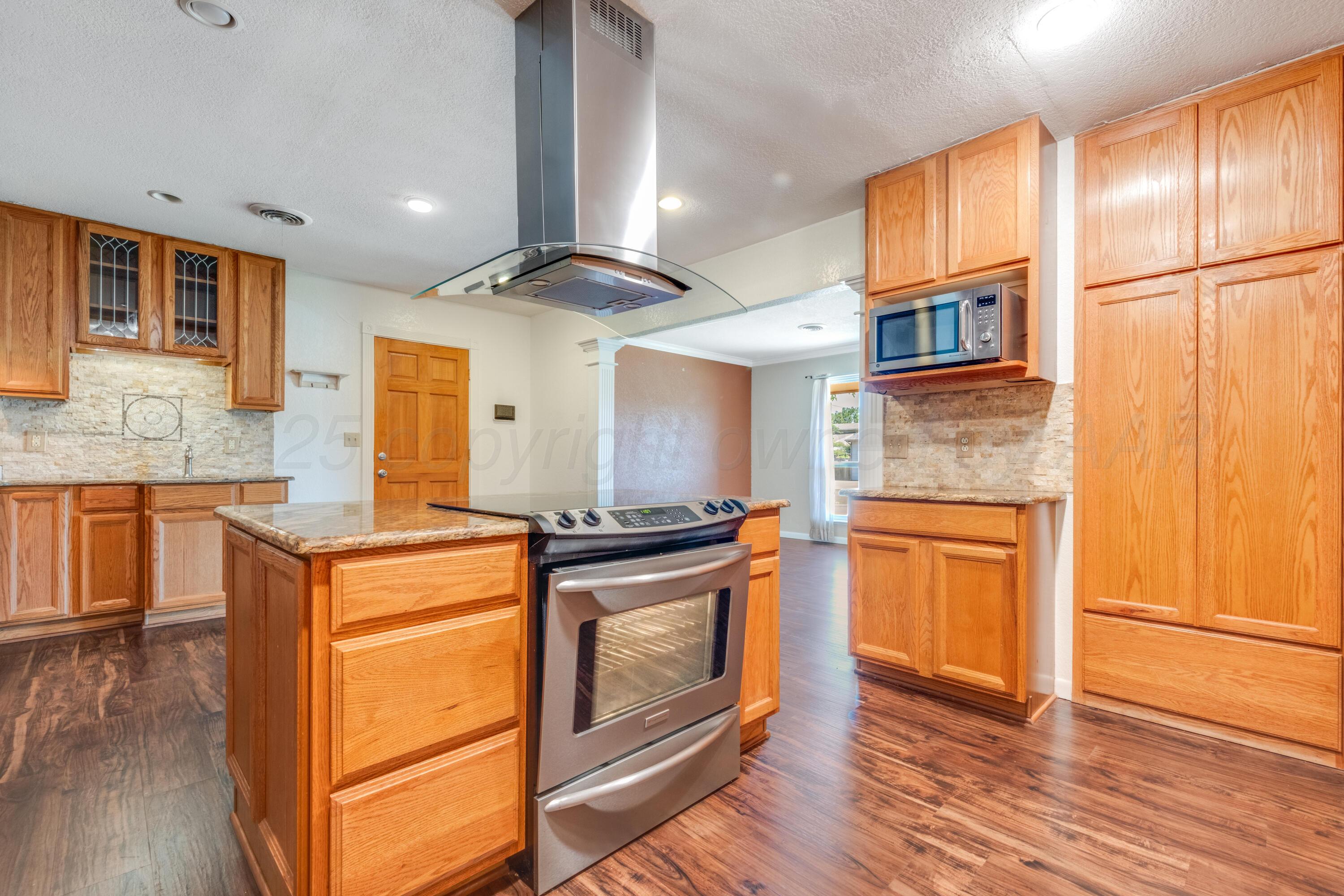 2401 Darrell Avenue Amarillo, TX 79110 - Photo 6 of 35 a kitchen with stainless steel appliances granite countertop a stove a sink and a refrigerator