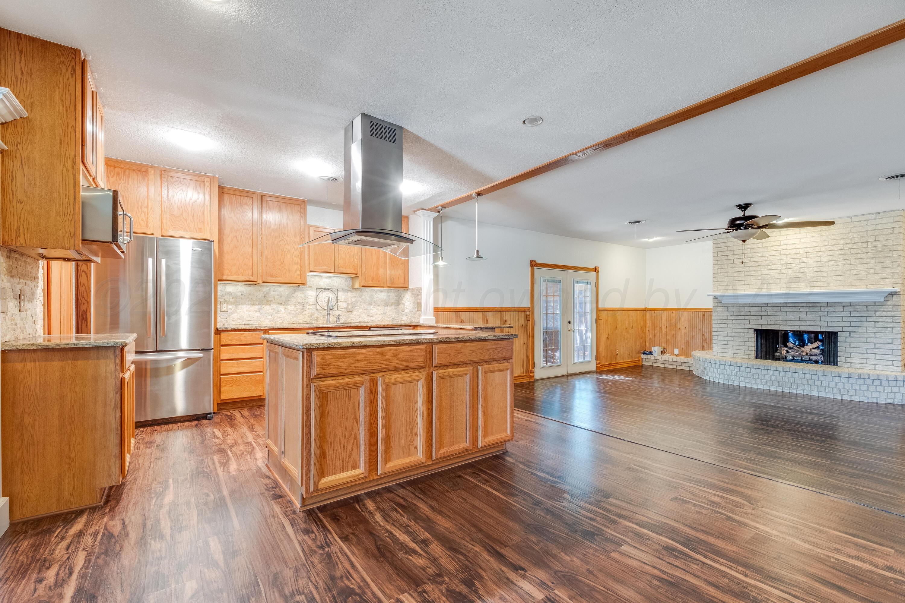 2401 Darrell Avenue Amarillo, TX 79110 - Photo 7 of 35 a kitchen with stainless steel appliances granite countertop a refrigerator a sink dishwasher a stove and white countertops with wooden floor