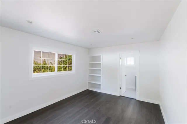 an empty room with wooden floor and window