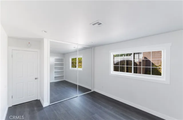 an empty room with windows and closet