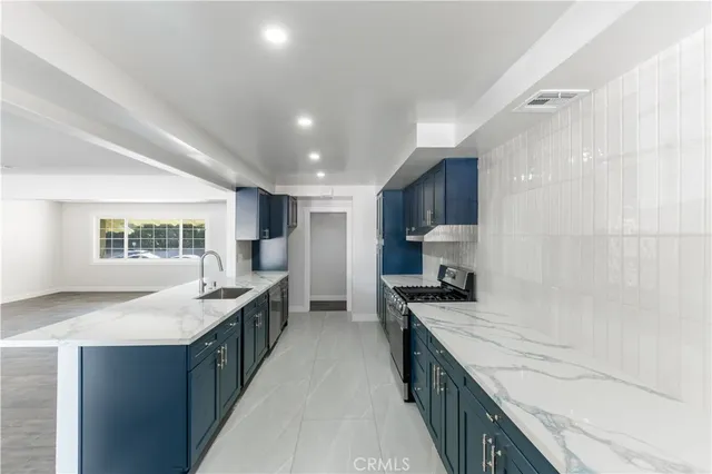 a kitchen with granite countertop a stove and a sink