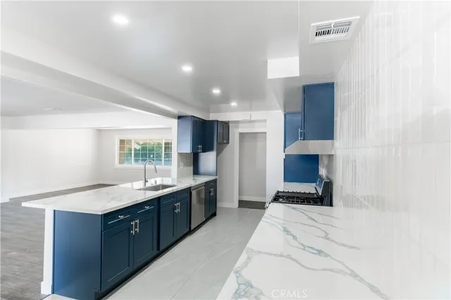 a large white kitchen with a sink and a large window
