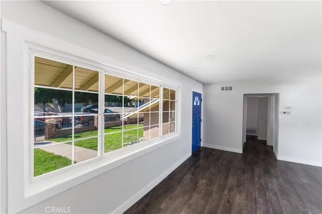 a view of empty room with wooden floor and windows