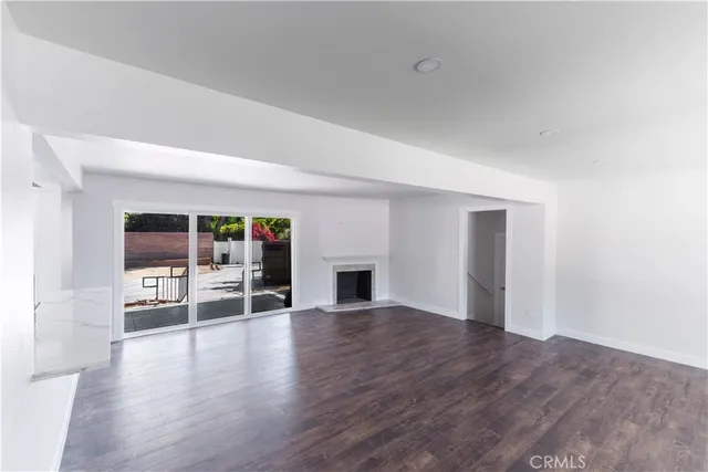 an empty room with wooden floor and fireplace