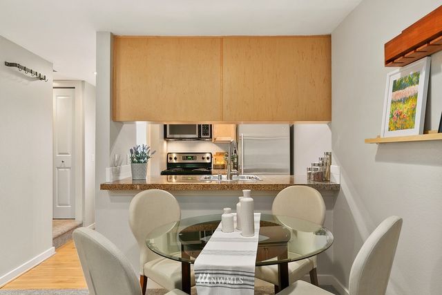 a kitchen with a table chairs refrigerator and microwave