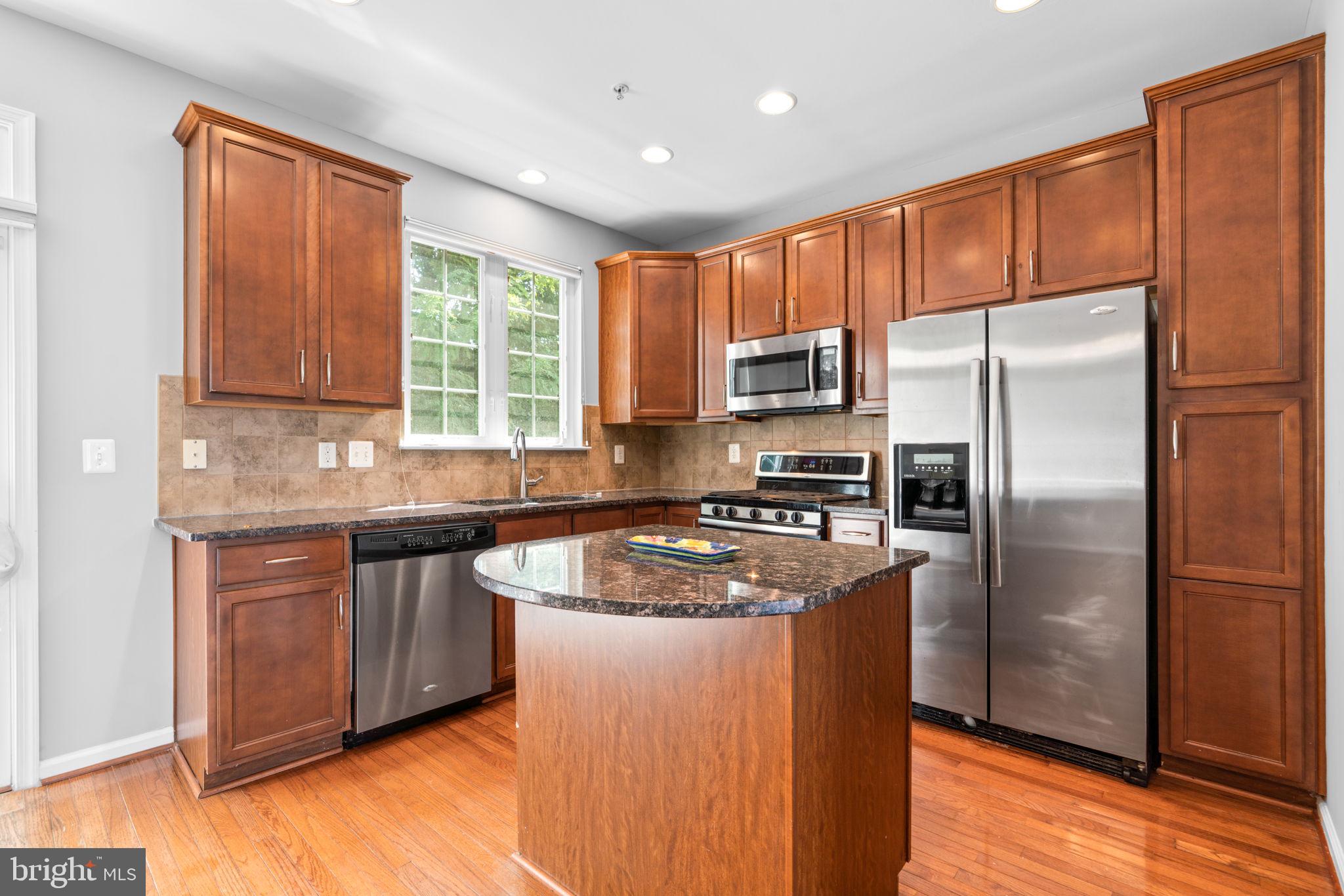 11646 Leesborough Circle Wheaton, MD 20902 - Photo 12 of 46 a kitchen with stainless steel appliances granite countertop a refrigerator a sink a stove a washer dryer and cabinets
