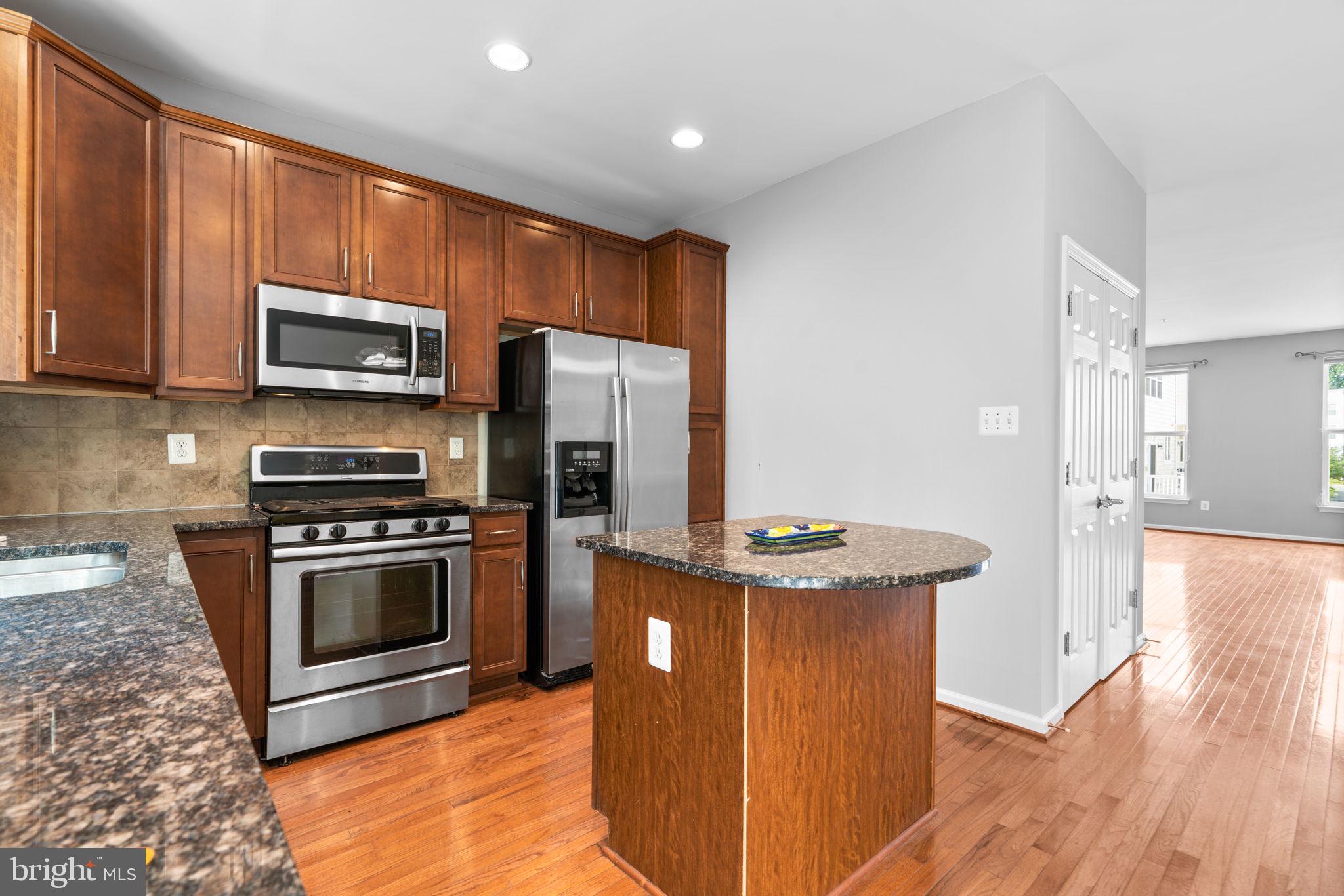 11646 Leesborough Circle Wheaton, MD 20902 - Photo 14 of 46 a kitchen with stainless steel appliances granite countertop a stove a refrigerator and a microwave