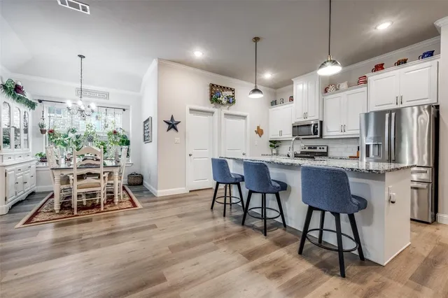a kitchen with stainless steel appliances kitchen island a refrigerator and a wooden cabinets
