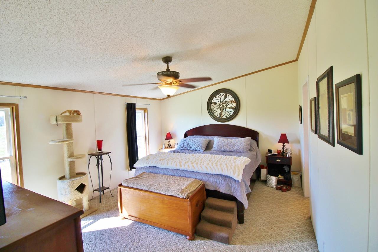 1119 Maple Hill Road Lebanon, TN 37087 - Photo 14 of 30 a bedroom with a bed and a chandelier