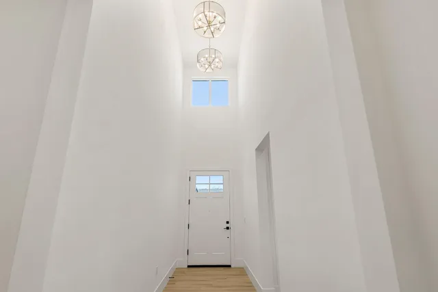 a large kitchen with stainless steel appliances a stove a refrigerator a sink and white cabinets with wooden floor