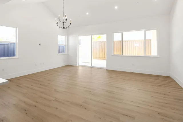 a view of kitchen view wooden floor cabinets and stainless steel appliances