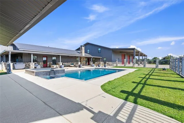 swimming pool view with a seating space and a garden view