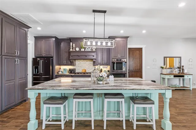 a kitchen with granite countertop a stove and refrigerator