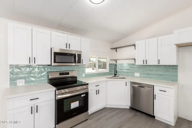 a kitchen with granite countertop white cabinets and white appliances