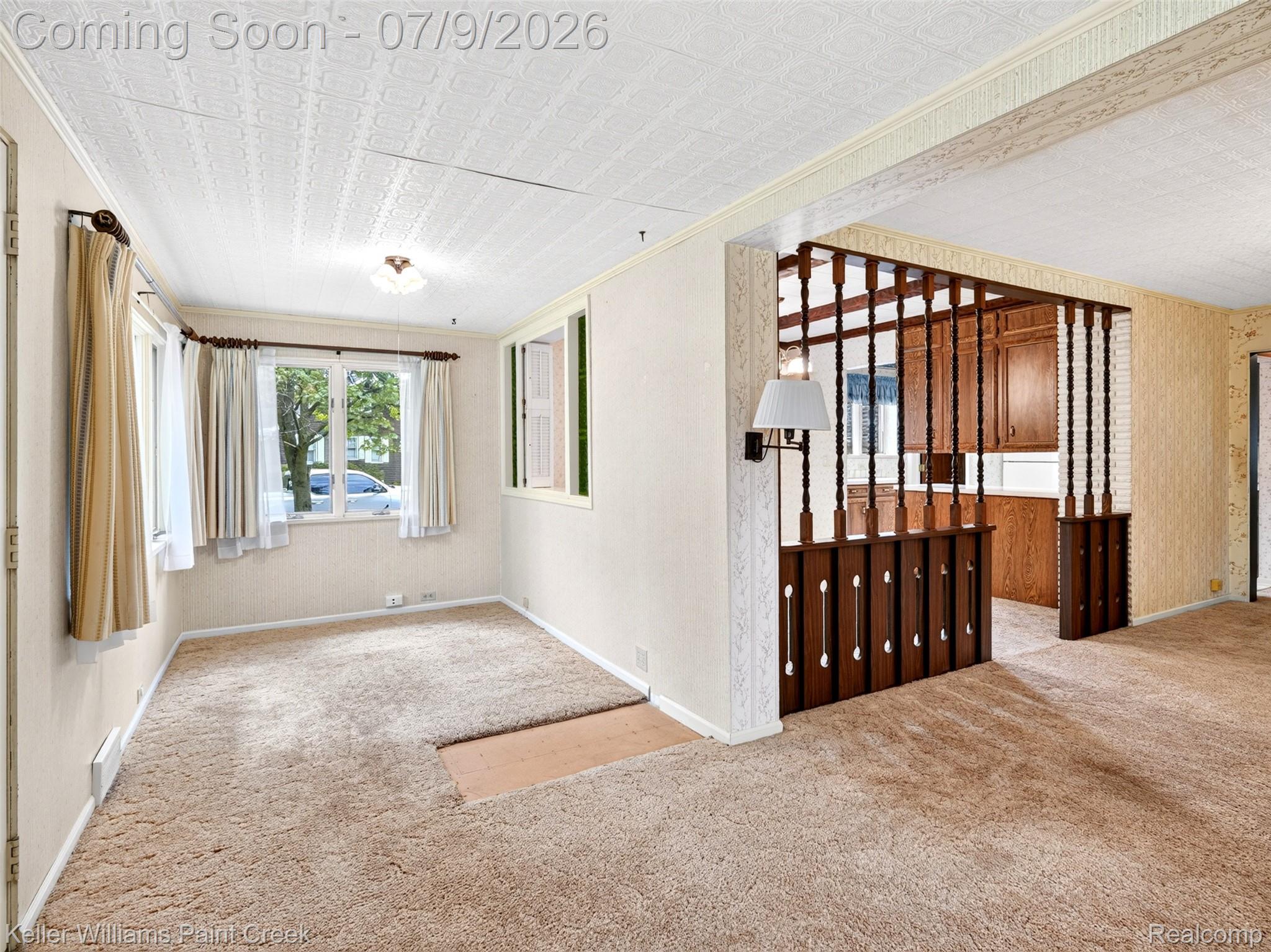 204 Russell Road Kawkawlin, MI 48631 - Photo 21 of 82 Carpeted living area featuring multiple windows with natural light, a textured ceiling, and a wall-mounted sconce