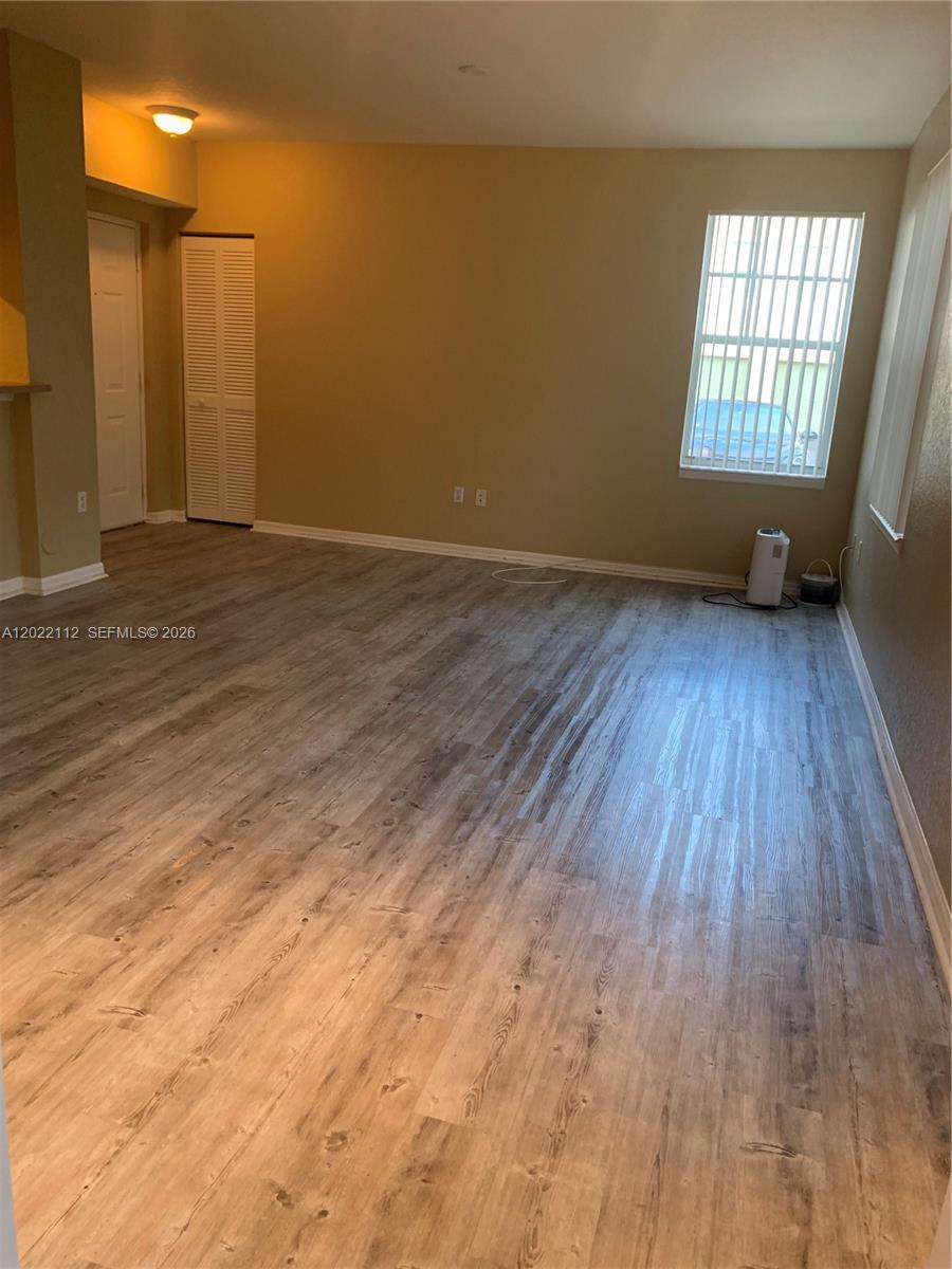 6572 West Sample Road, Unit 6572 Coral Springs, FL 33067 - Photo 17 of 17 an empty room with wooden floor and windows