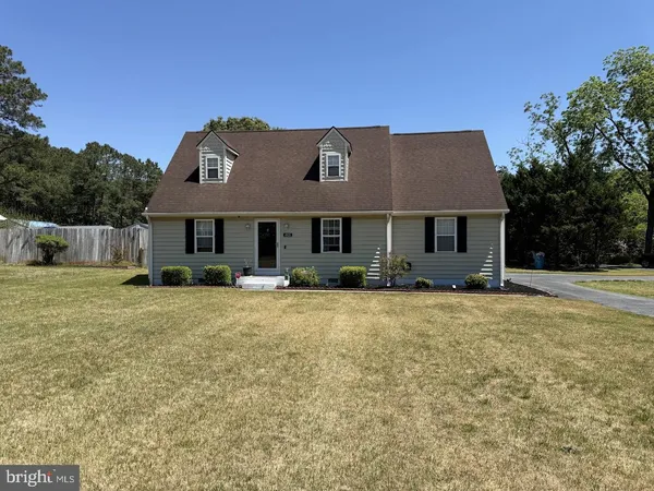 a front view of a house with a garden and yard