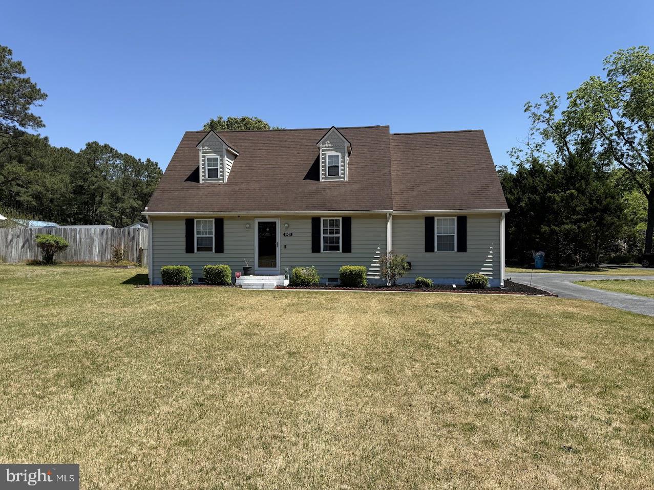 a front view of a house with a garden and yard