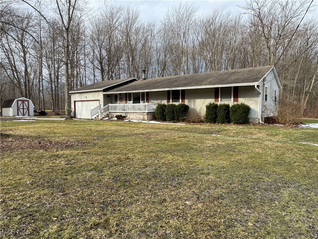 8631 Center Road Ashtabula, OH 44004 - Photo 2 of 25 Ranch-style house featuring an outbuilding, a porch, an attached garage, a storage unit, and a front lawn