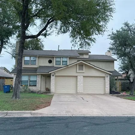 a front view of a house with a garden and trees