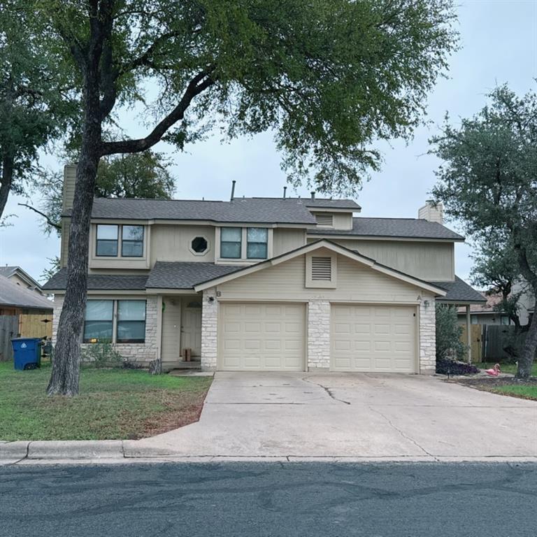 a front view of a house with a garden and trees