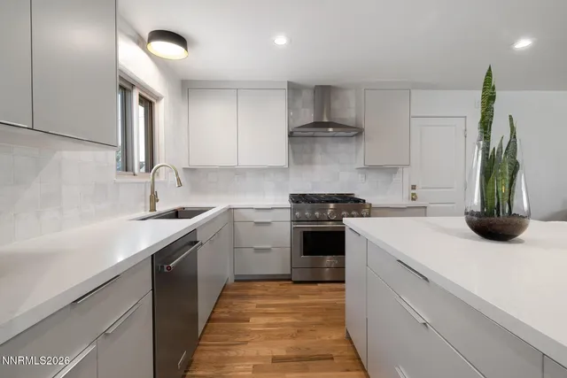 a kitchen with a sink dishwasher stove and white cabinets