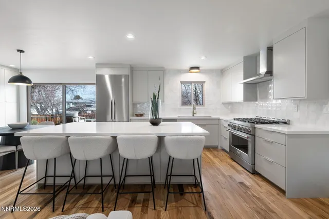 a kitchen with a dining table chairs and white cabinets