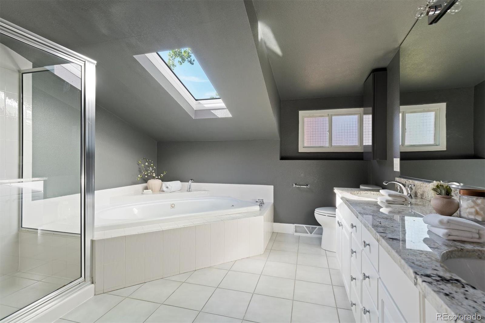 1643 South Ogden Street Denver, CO 80210 - Photo 21 of 39 a spacious bathroom with a double vanity sink mirror and bathtub