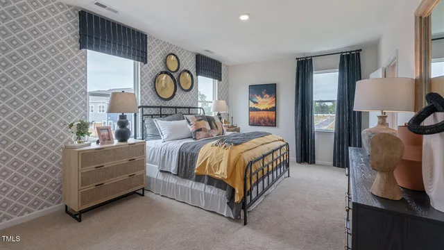 a bedroom with a bed and a lamp on dresser