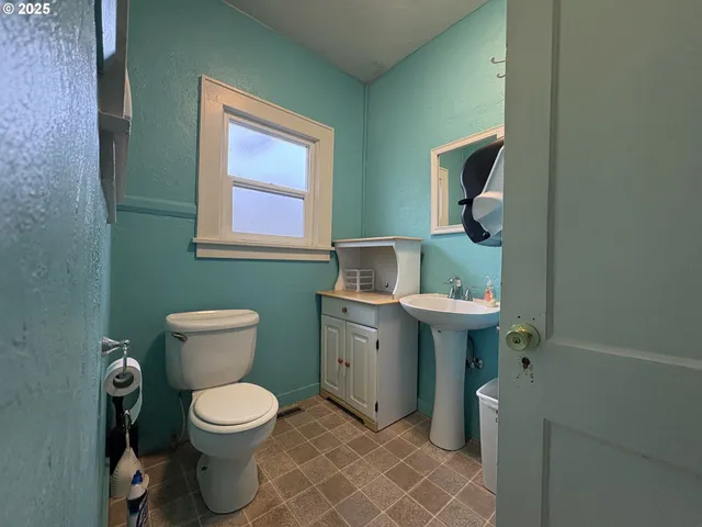 a bathroom with a toilet sink and mirror