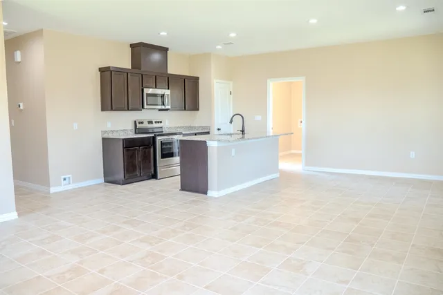 a view of kitchen with stainless steel appliances a sink and a refrigerator