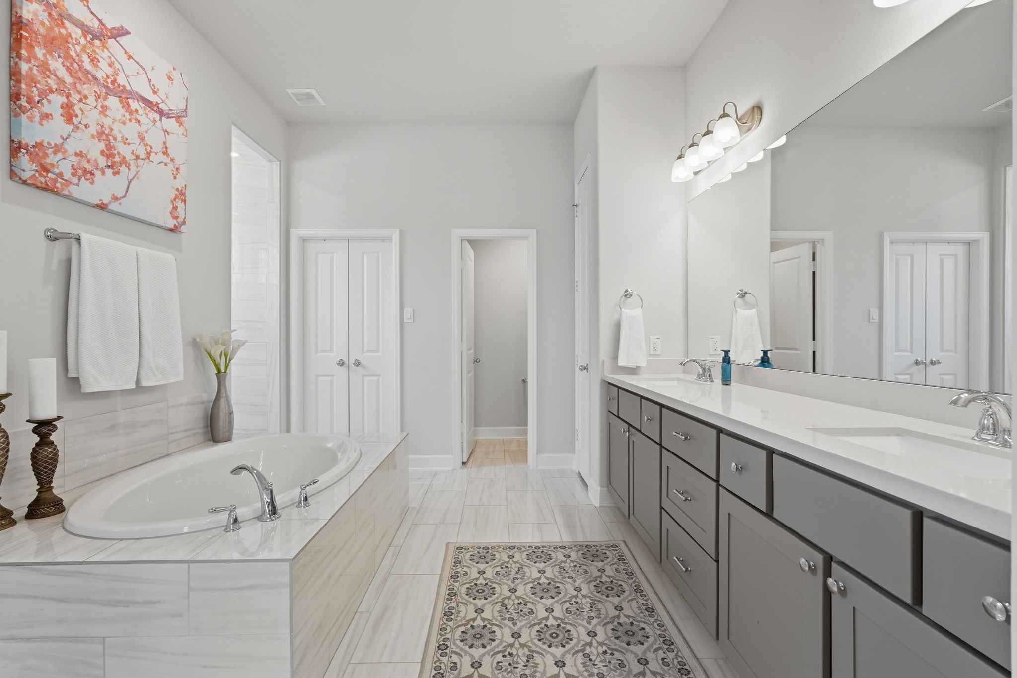 25011 Oxbow Lake Lane Spring, TX 77389 - Photo 21 of 33 a bathroom with a double vanity sink a large mirror a bathtub and