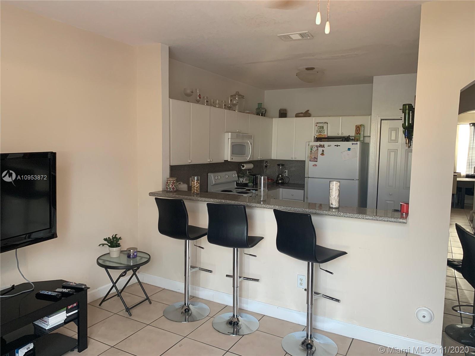 3915 Southwest 155th Avenue, Unit 313 Miramar, FL 33027 - Photo 5 of 10 a kitchen with stainless steel appliances a refrigerator and a stove top oven