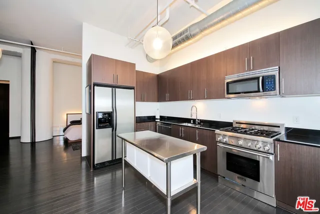 a kitchen with stainless steel appliances granite countertop a sink a stove and a refrigerator