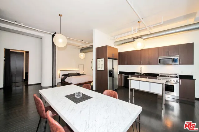 a kitchen with stainless steel appliances a refrigerator and a stove top oven