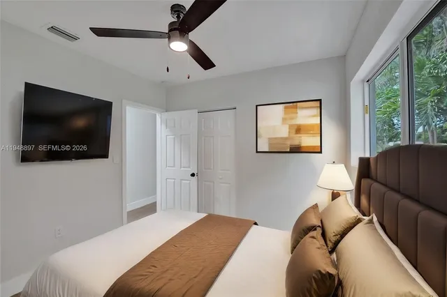 a bedroom with a bed and a flat screen tv