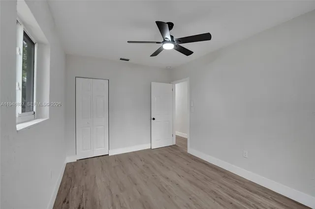 a view of empty room with wooden floor
