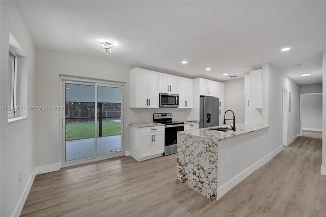 a kitchen with granite countertop a sink stove and refrigerator
