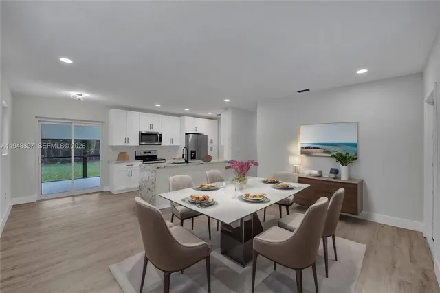 a view of a dining room with furniture wooden floor and a kitchen