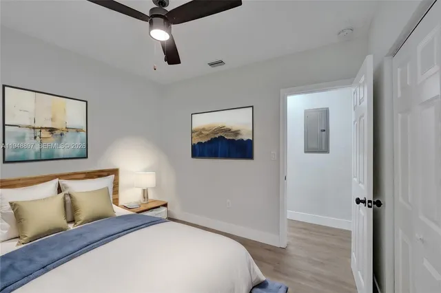 a bedroom with a bed and wooden floor