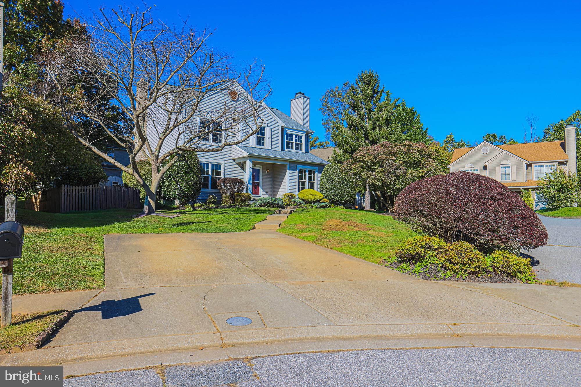 a view of yellow house with a yard and plants