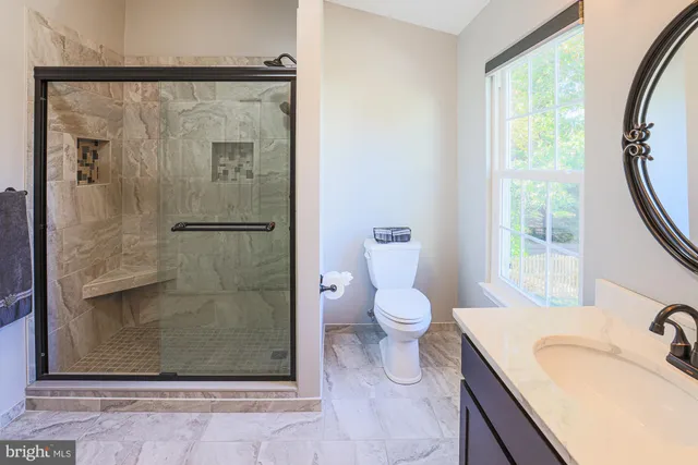 a bathroom with a granite countertop sink toilet and shower