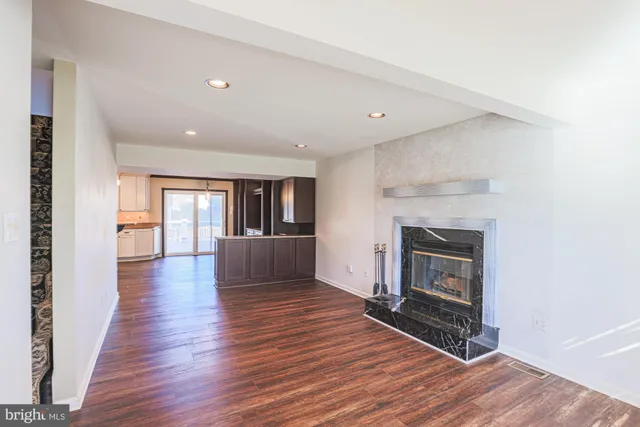 a view of empty room with wooden floor and fireplace