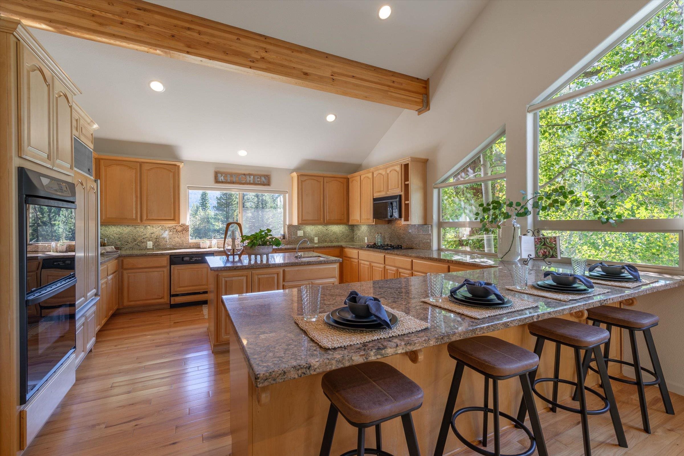 192 Hidden Lake Loop Olympic Valley, CA 96146 - Photo 10 of 21 a kitchen with stainless steel appliances granite countertop table chairs sink and wooden floor