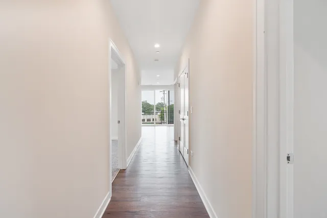a view of a hallway with wooden floor