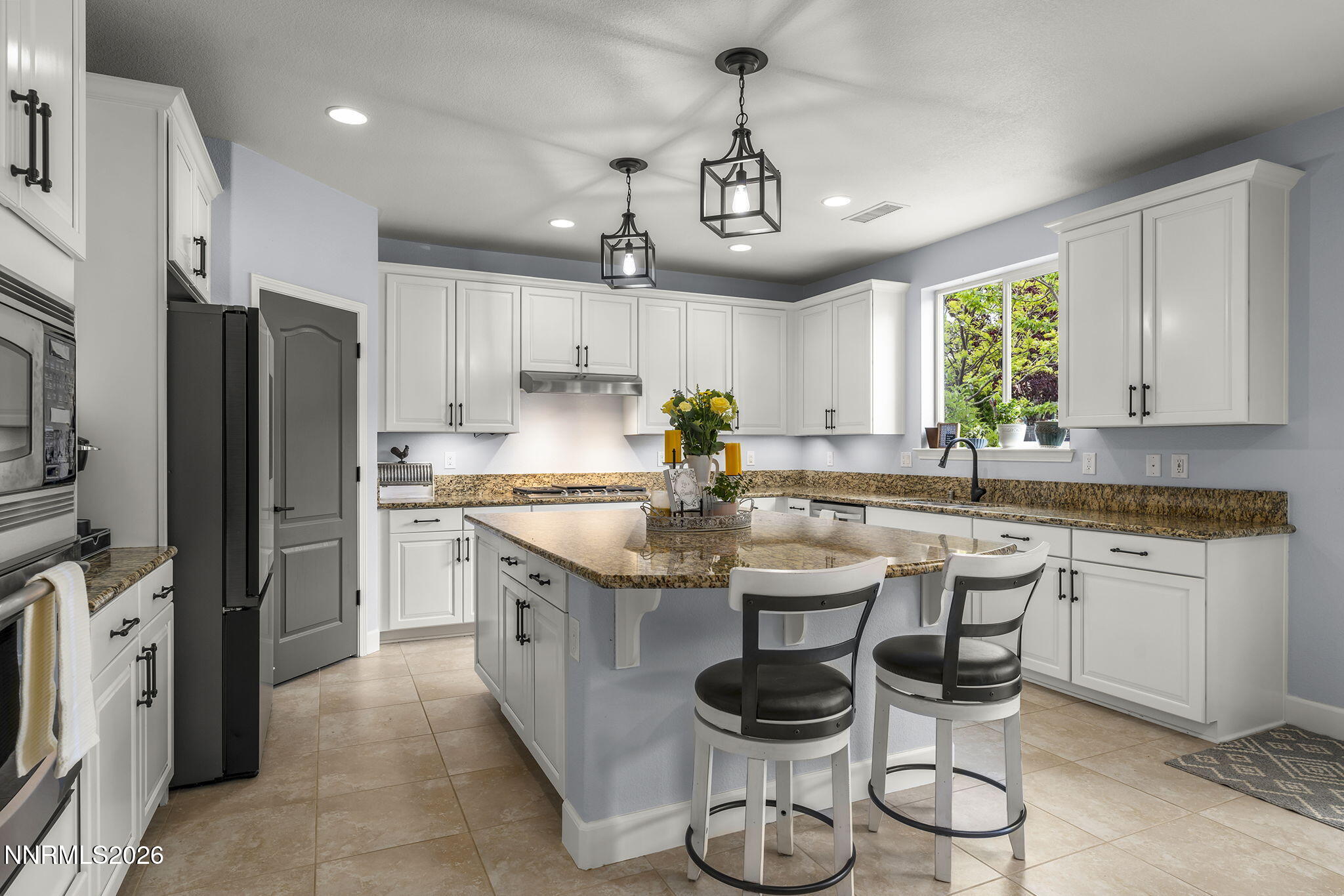 2960 Tobiano Drive Reno, NV 89521 - Photo 23 of 77 a kitchen with stainless steel appliances granite countertop a sink a stove a refrigerator cabinets and chairs