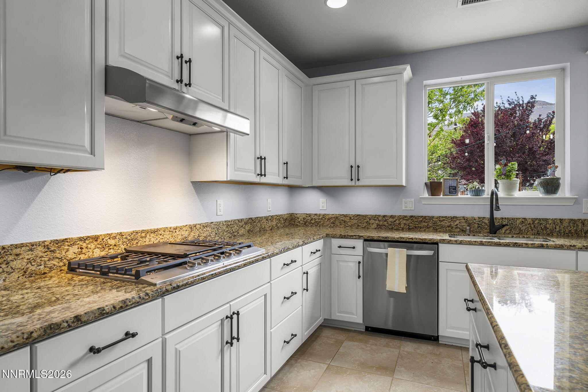 2960 Tobiano Drive Reno, NV 89521 - Photo 25 of 77 a kitchen with granite countertop white cabinets white appliances and a wide window