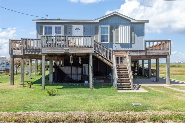a front view of a house with a garden and deck