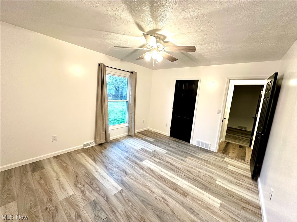 2039 St Johns Road Colliers, WV 26035 - Photo 21 of 35 Unfurnished bedroom featuring light hardwood / wood-style flooring, a textured ceiling, and ceiling fan